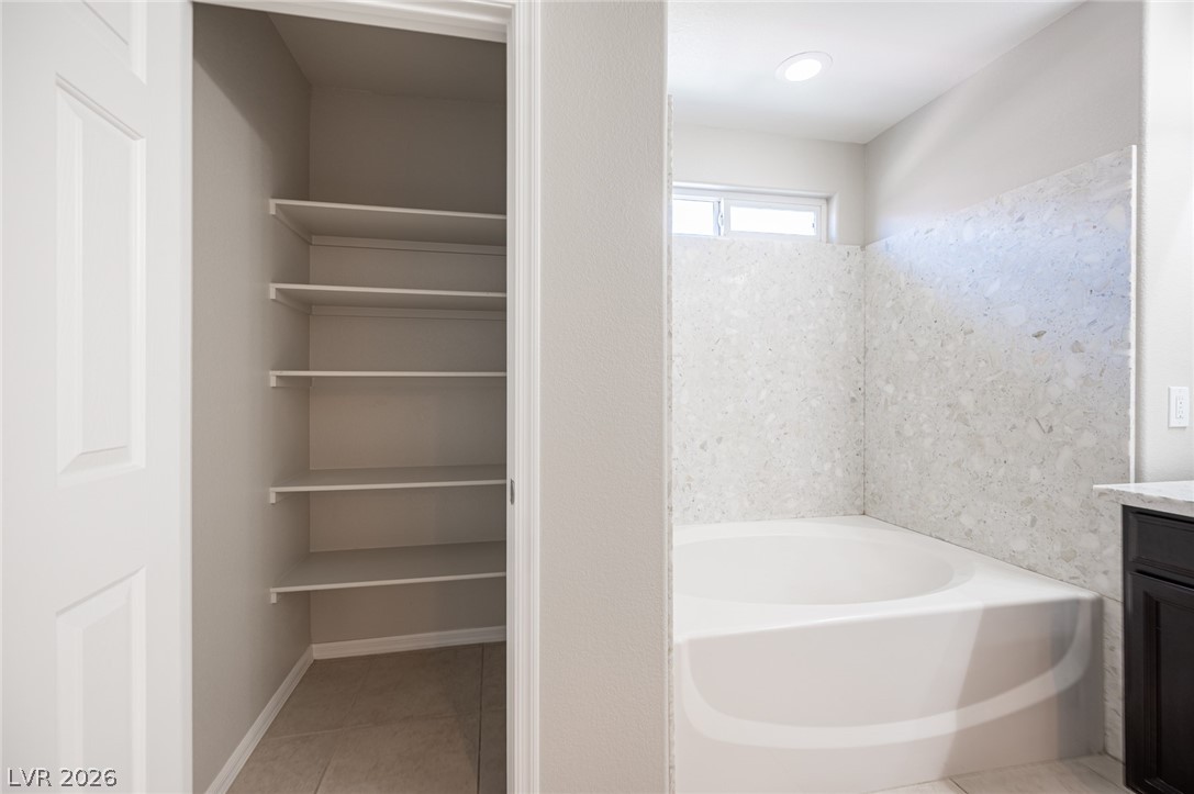 9916 Sable Point Street Las Vegas, NV 89178 - Photo 49 of 73 A deep soaking tub with a tiled surround offers a perfect spot for relaxation.