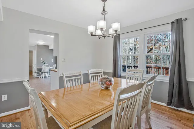 a view of a dining room with furniture a chandelier and wooden floor