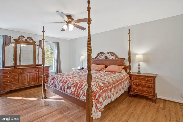 a bedroom with a bed a chandelier and dresser