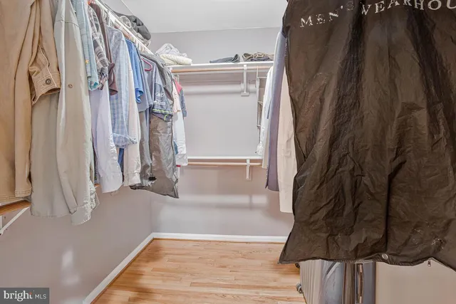 a view of walk in closet with clothes and shoes