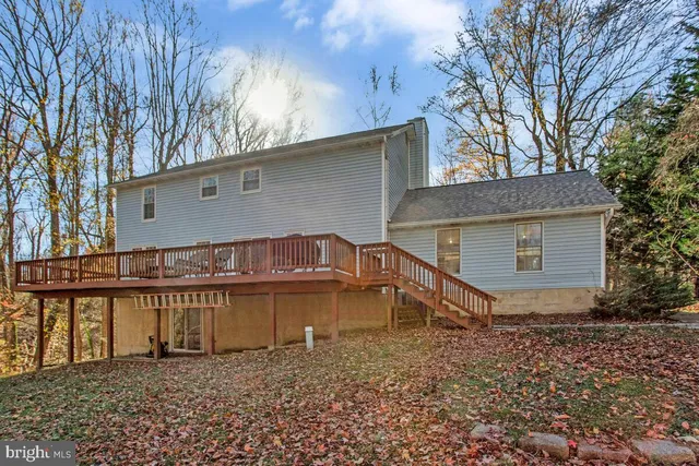 a view of a house with a yard and large tree