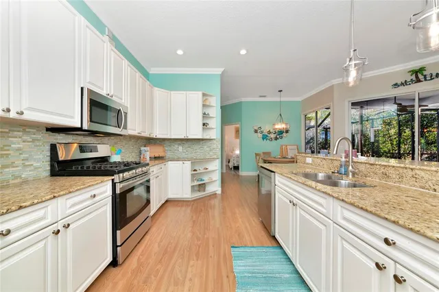 a kitchen with stainless steel appliances granite countertop wooden cabinets a stove a sink and dishwasher