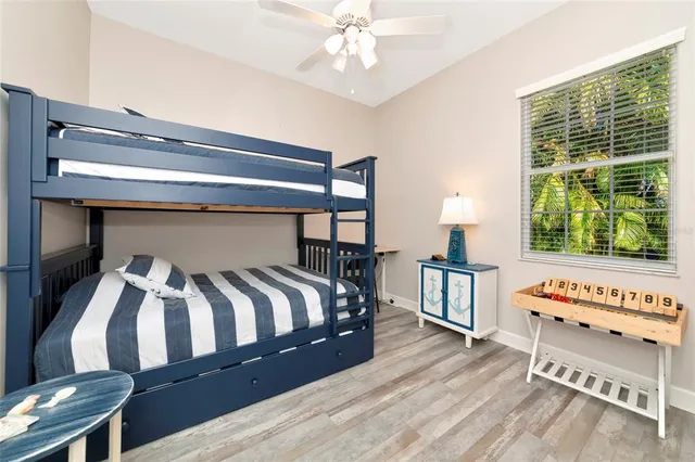 a bedroom with a bed a dresser and a large window