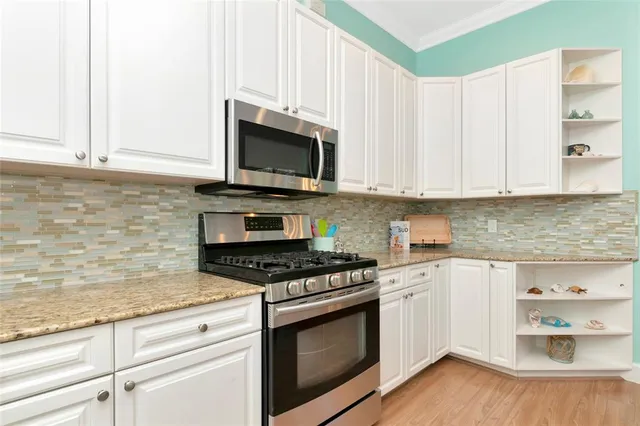 a kitchen with granite countertop white cabinets and appliances