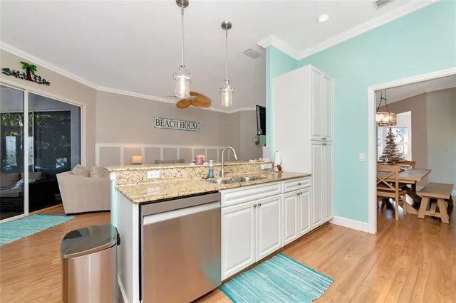 a kitchen with granite countertop a sink stove and wooden floor