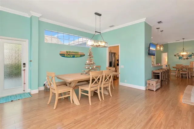 a dining room with furniture a chandelier and wooden floor