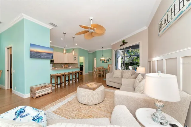 a living room with furniture kitchen view and a wooden floor