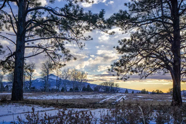 a view of mountain with sunset in background