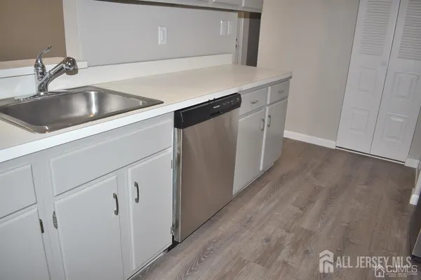 a view of a kitchen with wooden floor and a refrigerator