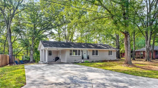 a view of a house with a patio and a yard