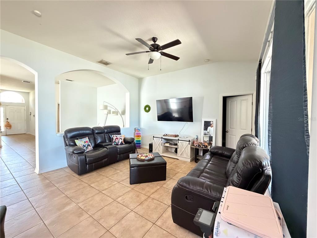 945 Tramells Trail Kissimmee, FL 34744 - Photo 9 of 36 a living room with furniture and a flat screen tv