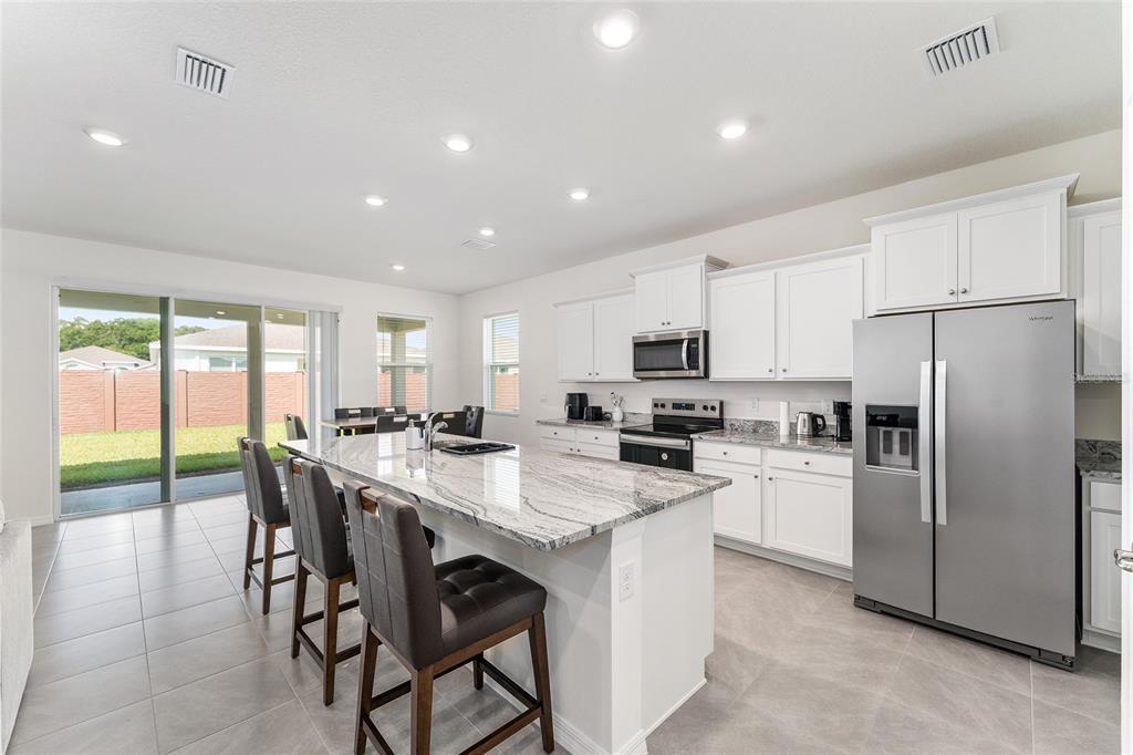 4098 Northwest 48th Terrace Ocala, FL 34482 - Photo 17 of 58 a kitchen with refrigerator a stove and a center island