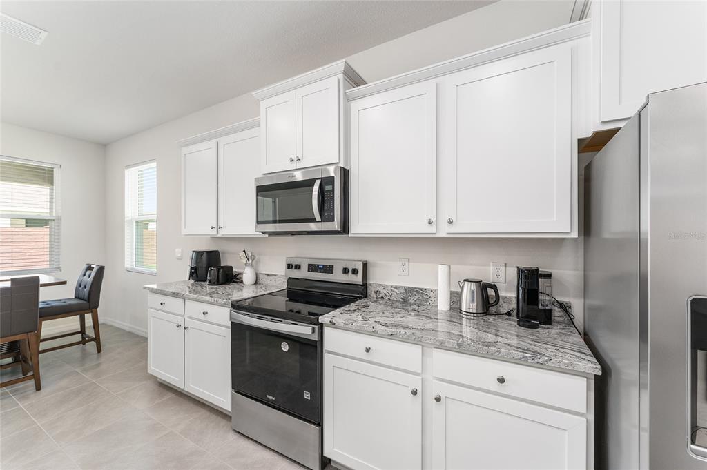 4098 Northwest 48th Terrace Ocala, FL 34482 - Photo 19 of 58 a kitchen with stainless steel appliances granite countertop white cabinets sink and a refrigerator