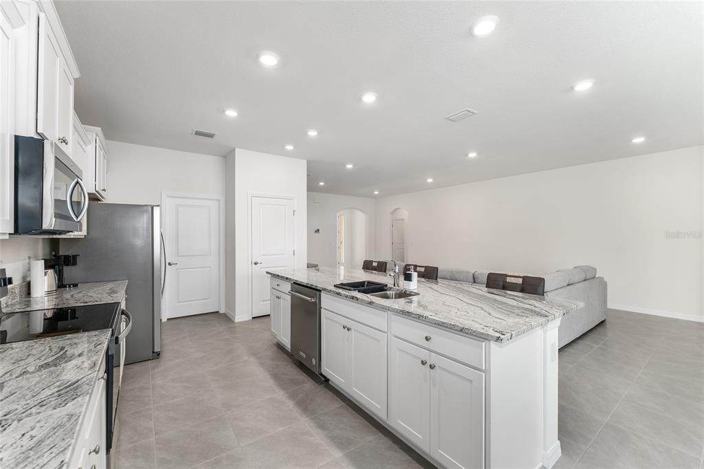 4098 Northwest 48th Terrace Ocala, FL 34482 - Photo 20 of 58 a kitchen with stainless steel appliances granite countertop a sink stove and refrigerator