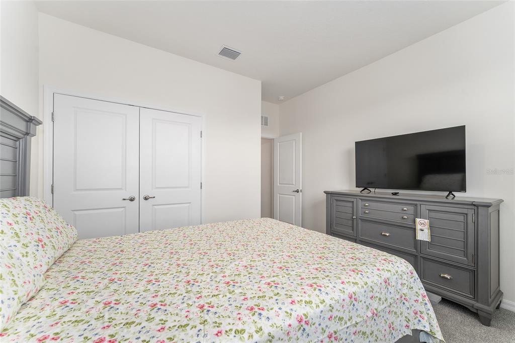 4098 Northwest 48th Terrace Ocala, FL 34482 - Photo 47 of 58 a bedroom with a bed and a flat screen tv in white walls