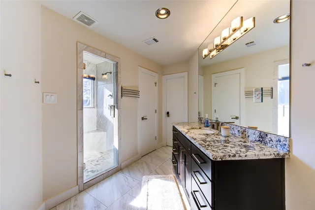 a bathroom with a granite countertop sink toilet and shower