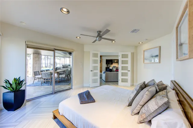 a spacious bedroom with a bed and a flat screen tv