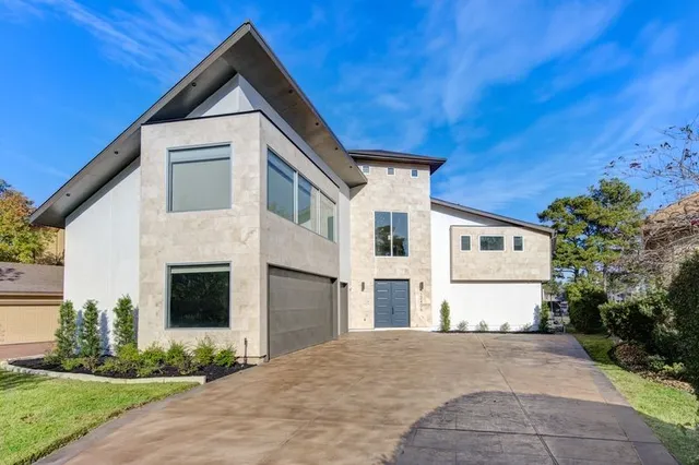 a view of a white house with a yard and potted plants