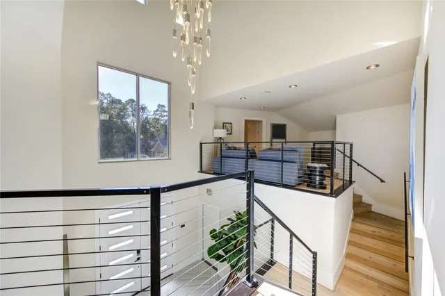 a view of a hallway with wooden floor and staircase