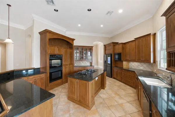 a kitchen that has a lot of cabinets in it and wooden floors