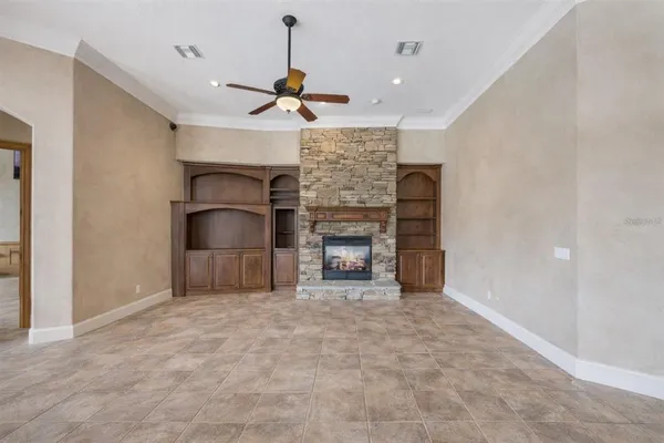 a view of an empty room with a fireplace and a window
