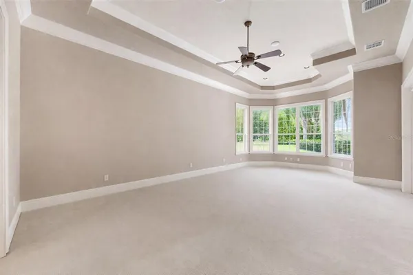 a spacious bedroom with a bed and a chandelier
