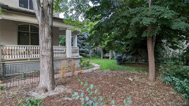 a view of a house with a yard and large tree