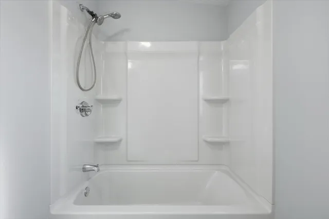 a bathroom with a bath tub with shower