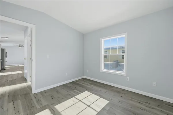 an empty room with wooden floor and a window