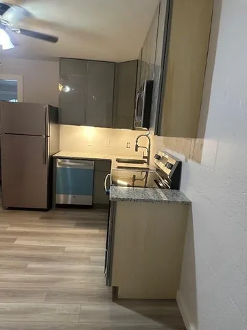 a kitchen with stainless steel appliances granite countertop a sink stove and refrigerator