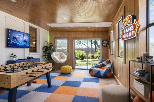 a living room with furniture a rug and a floor to ceiling window