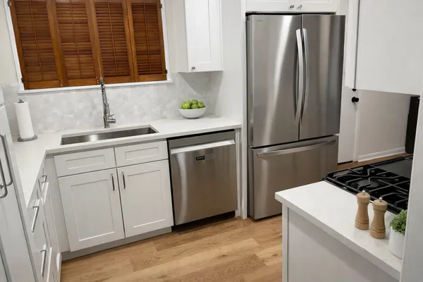 a kitchen with white cabinets and stainless steel appliances