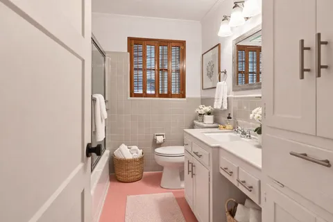 a spacious bathroom with a double vanity sink a mirror and a toilet
