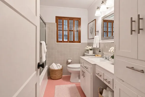 a spacious bathroom with a double vanity sink a mirror and a toilet