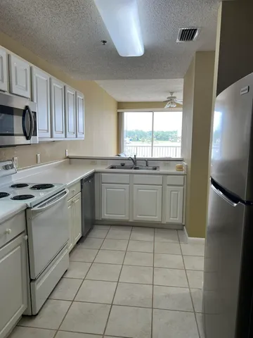 a kitchen with a sink a refrigerator and cabinets