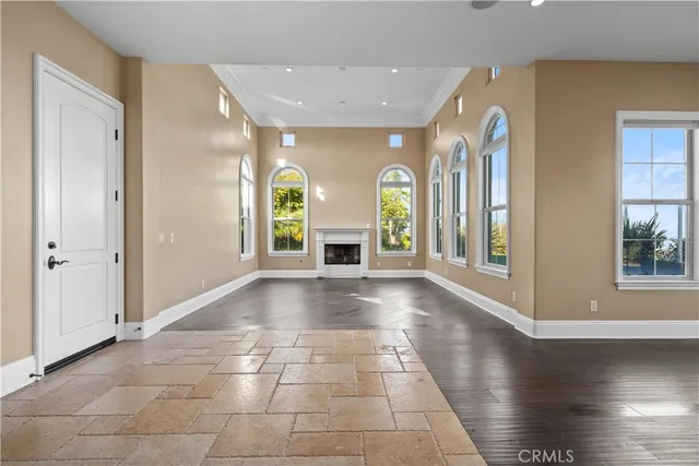 a view of an empty room with window and fire place