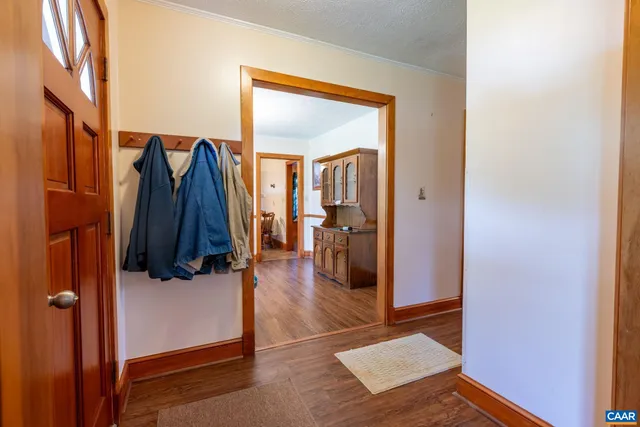 a kitchen with stainless steel appliances granite countertop a refrigerator a sink dishwasher a stove and white cabinets with wooden floor