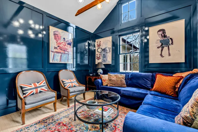 a living room with furniture and a painting on the wall