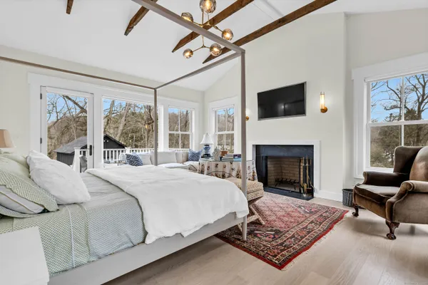 a bedroom with a bed a couch and large window