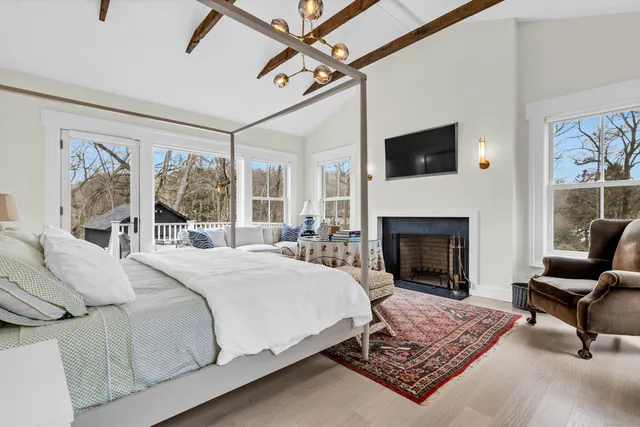 a bedroom with a bed a couch and large window