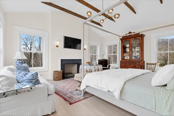 a bedroom with a large bed and a fireplace