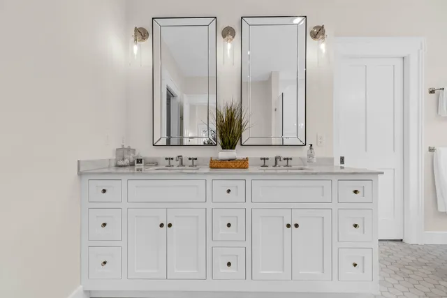 a bathroom with white cabinets and a sink