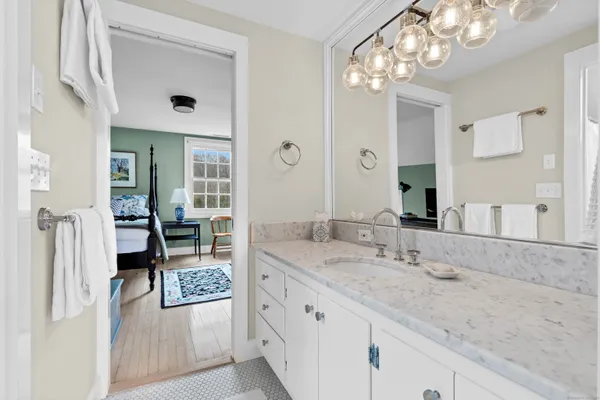 a spacious bathroom with a granite countertop sink a mirror and shower