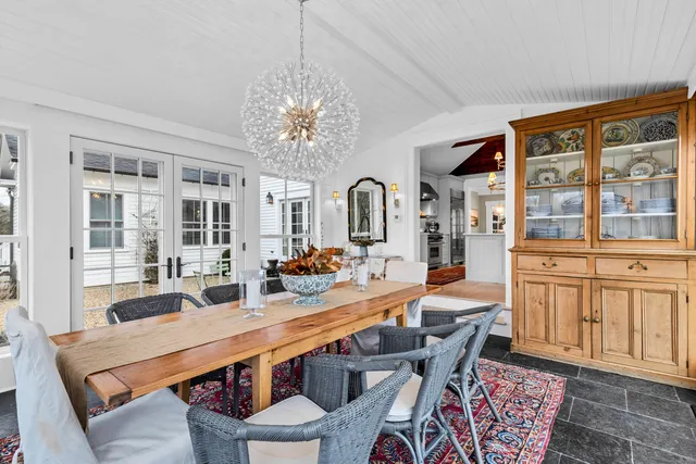 a dining room with furniture a chandelier and window