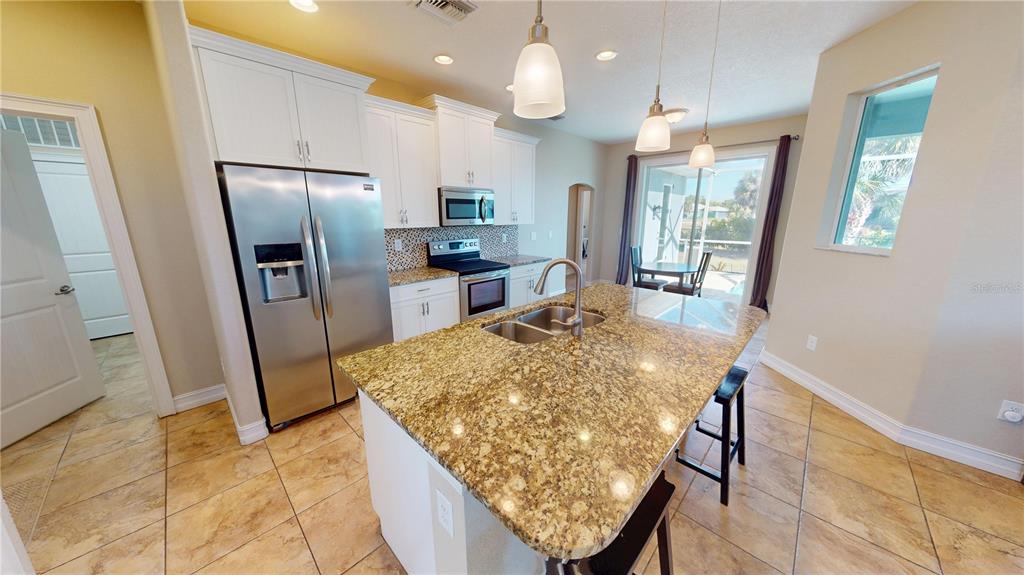 7342 North Ficus Tree Punta Gorda, FL 33955 - Photo 9 of 34 a kitchen with stainless steel appliances granite countertop sink refrigerator and microwave