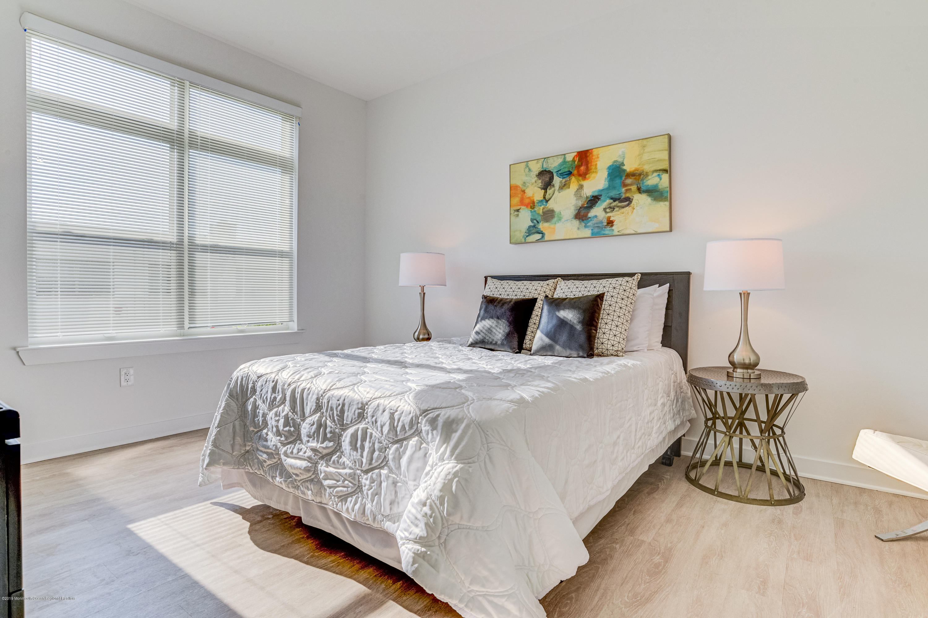 55 West Front Street, Unit 306 Red Bank, NJ 07701 - Photo 12 of 24 a bed sitting in a bedroom next to a window