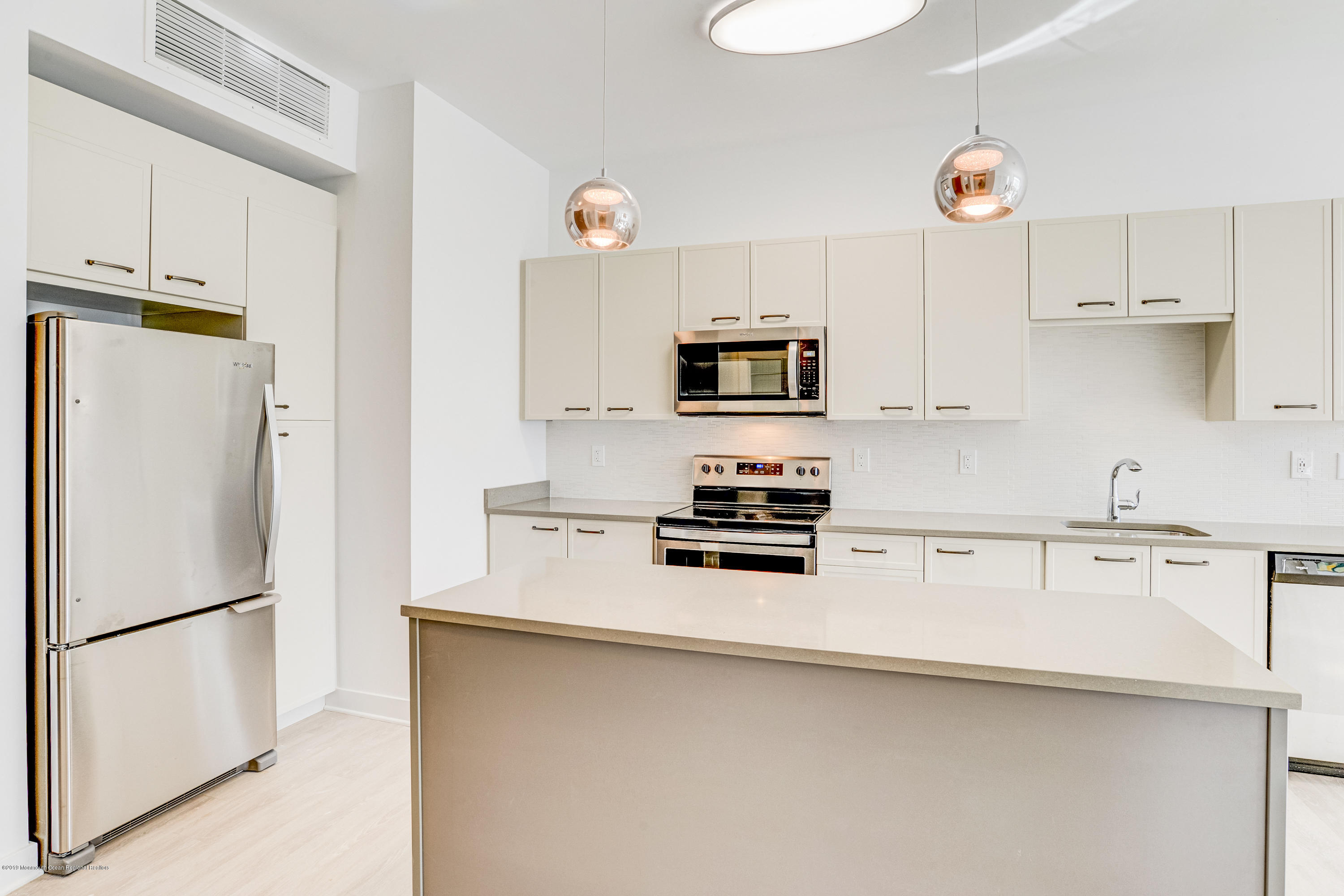 55 West Front Street, Unit 306 Red Bank, NJ 07701 - Photo 8 of 24 a kitchen with stainless steel appliances a refrigerator a sink and white cabinets
