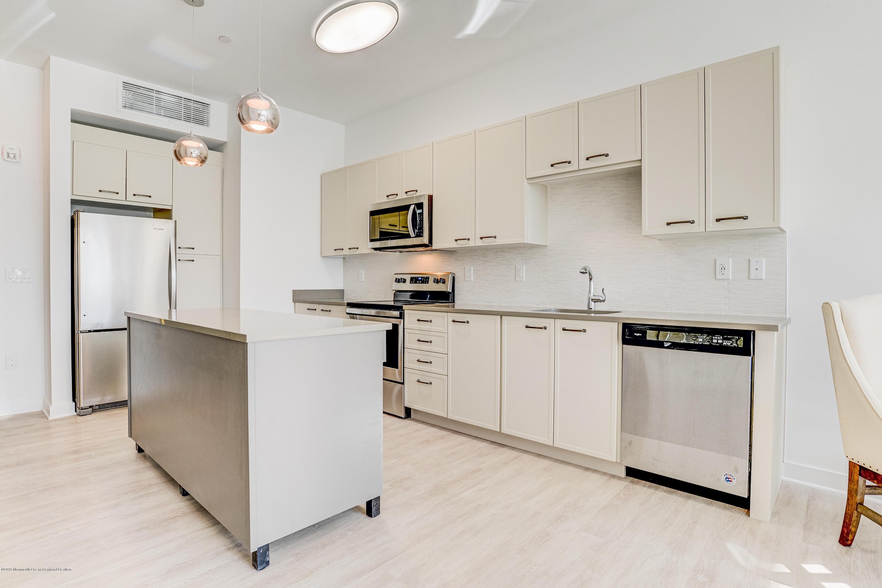 55 West Front Street, Unit 306 Red Bank, NJ 07701 - Photo 9 of 24 a kitchen with white cabinets and stainless steel appliances
