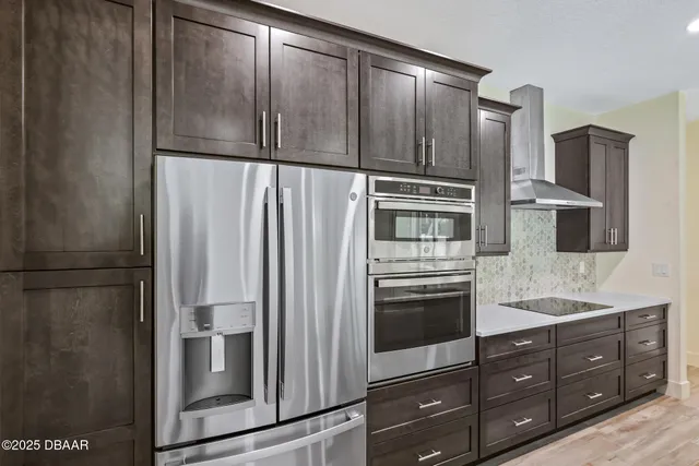 a kitchen with stainless steel appliances granite countertop a refrigerator and a sink