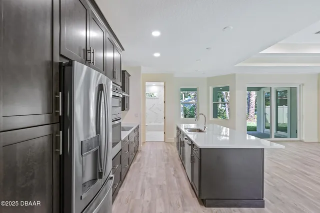 a open kitchen with stainless steel appliances granite countertop a refrigerator a sink and a stove
